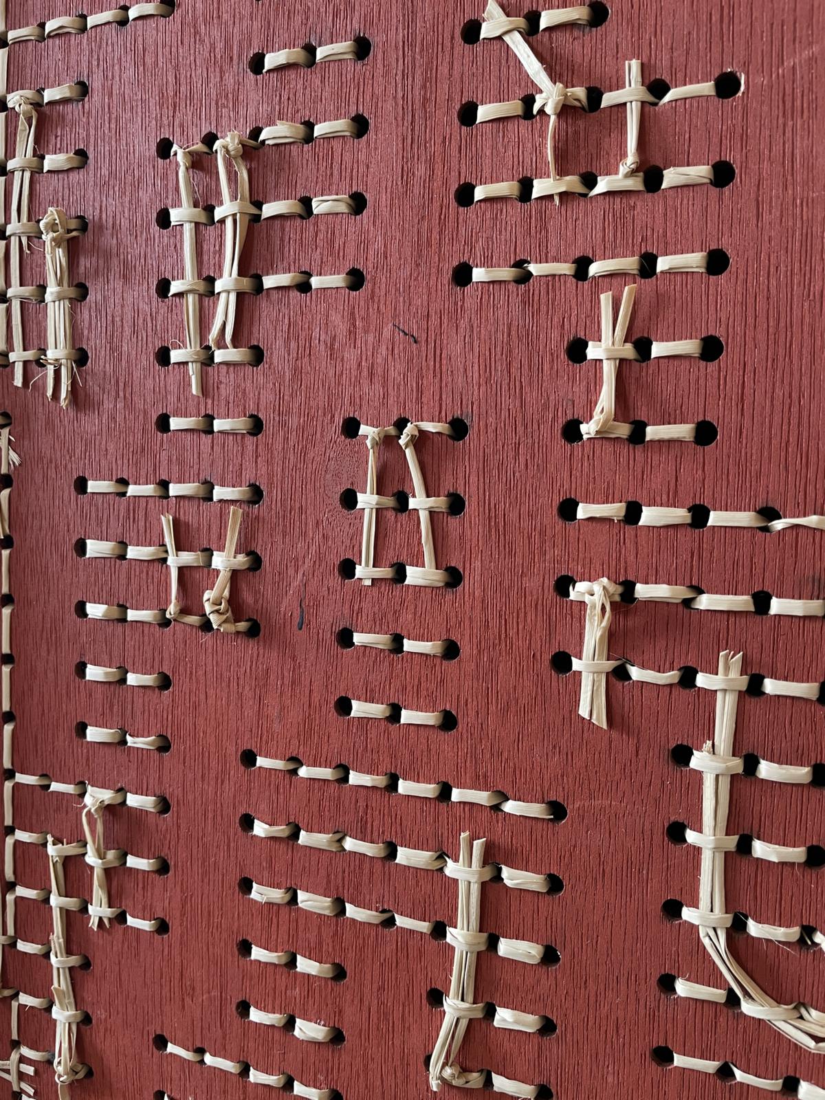 Poutama by Aka Whiro, the back: the ochre red board with the kiekie tied off through it.
