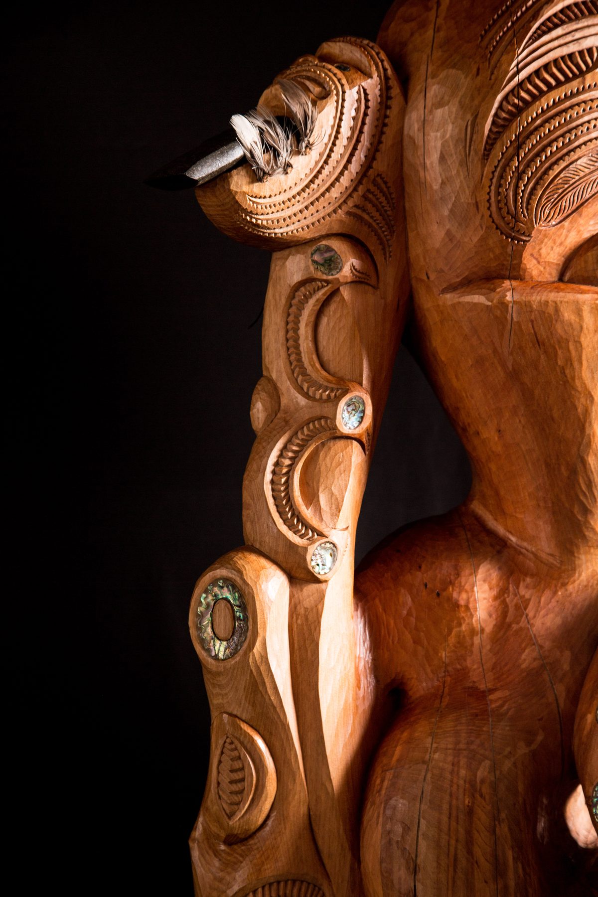 Te Ara Whakaiti: the hand holding the toki, the arm carved and inlaid with pāua.