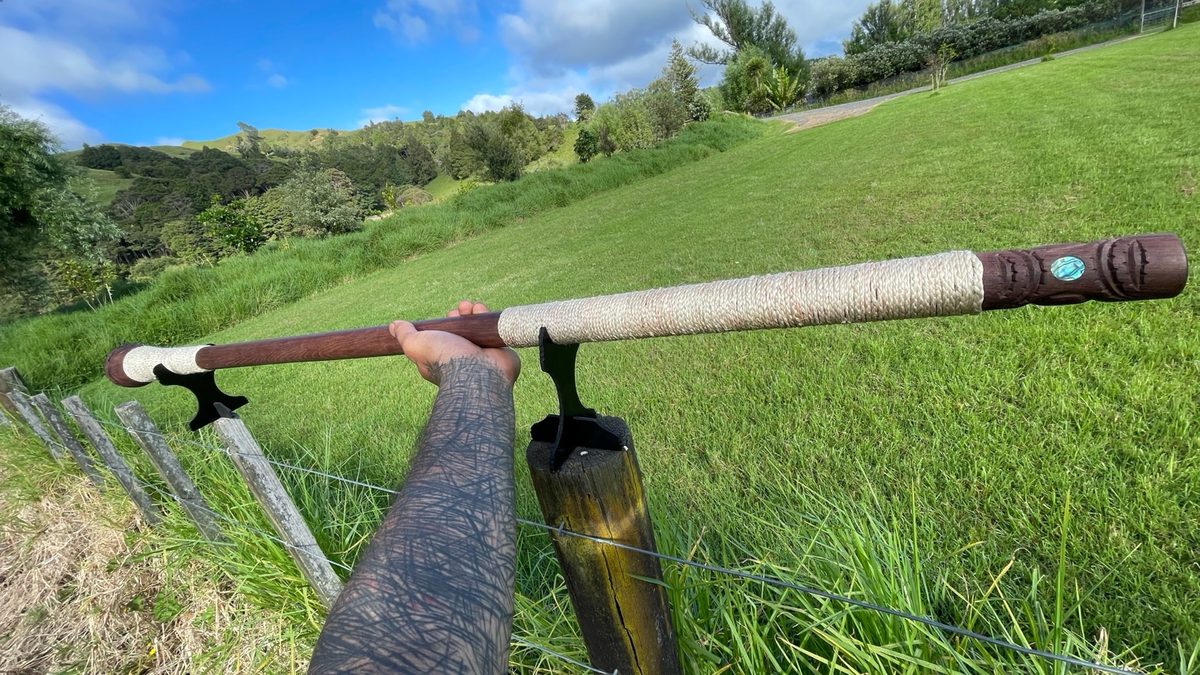 Te Rua o te Rata by Aka Whiro: a long rata trumpet, bound with muka and inlaid with pāua.